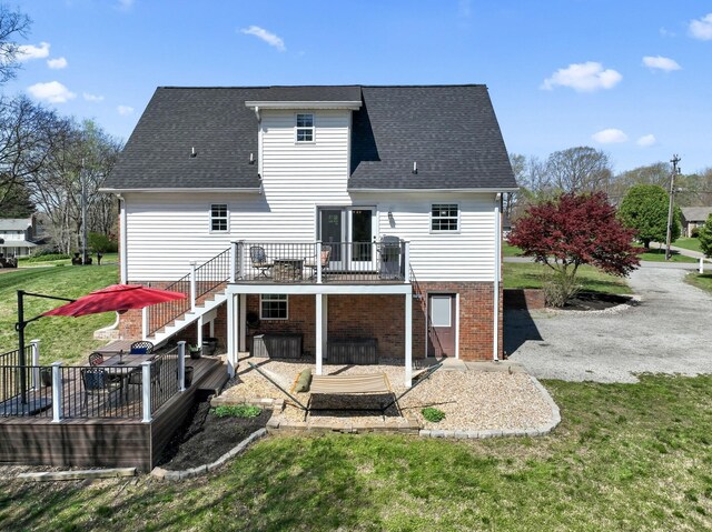 back of house featuring a wooden deck, stairway, a lawn, roof with shingles, and a patio area