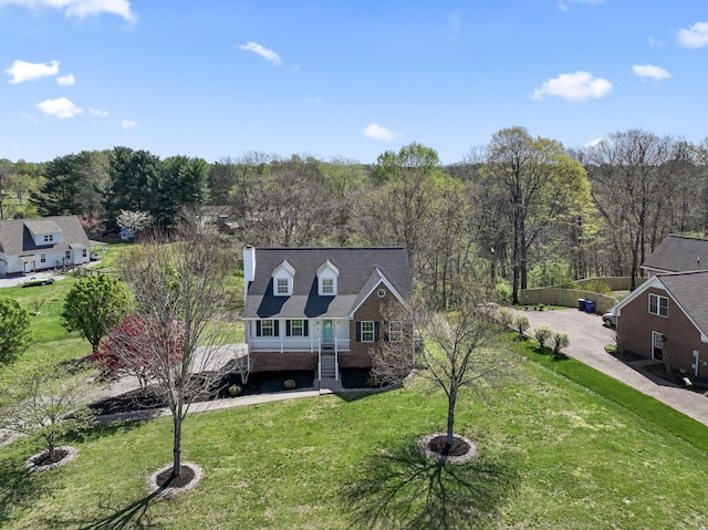 view of front of home with a front yard and a forest view