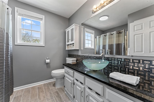 full bath featuring tasteful backsplash, vanity, baseboards, toilet, and wood finished floors