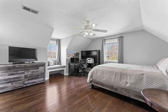 bedroom featuring wood finished floors, multiple windows, lofted ceiling, and visible vents