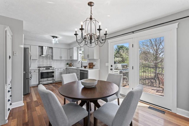 dining area featuring a chandelier, baseboards, dark wood-style floors, and visible vents