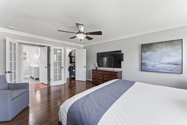 bedroom with hardwood / wood-style floors, french doors, crown molding, and a walk in closet