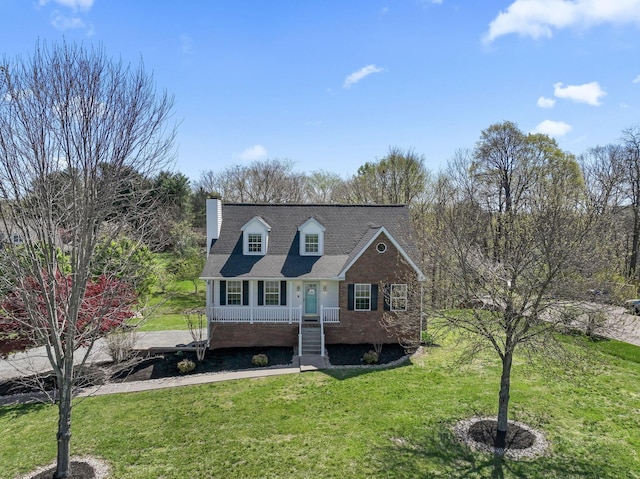 cape cod-style house with a front yard, a shingled roof, brick siding, and a chimney
