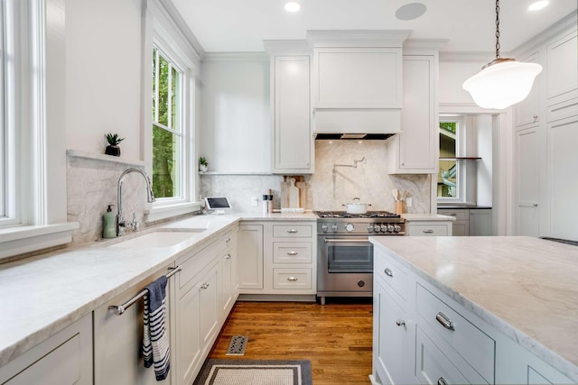 931 Caldwell Ln, Nashville, TN 37204 - kitchen with white cabinets, decorative light fixtures, a sink, wood finished floors, and stainless steel appliances