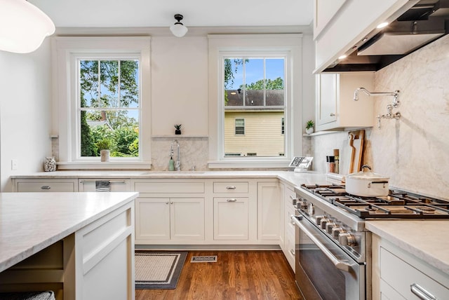 931 Caldwell Ln, Nashville, TN 37204 - kitchen with stainless steel stove, light countertops, visible vents, wall chimney exhaust hood, and a sink