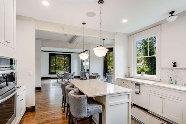 931 Caldwell Ln, Nashville, TN 37204 - kitchen featuring a sink, ornamental molding, plenty of natural light, and a kitchen bar