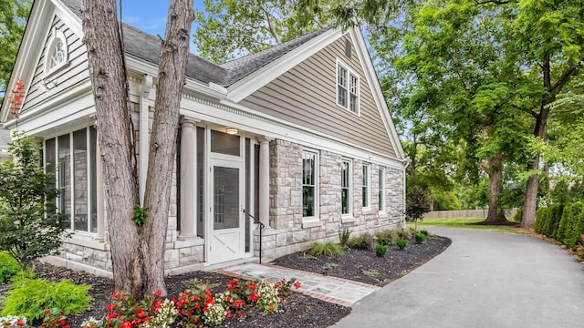 931 Caldwell Ln, Nashville, TN 37204 - view of home's exterior with a shingled roof, fence, and stone siding