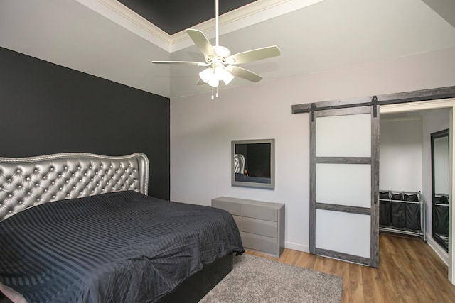 4512 General Forest Cir, Bon Aqua, TN 37025 - bedroom with baseboards, a barn door, ceiling fan, crown molding, and wood finished floors