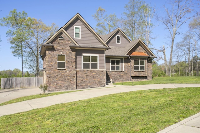 4512 General Forest Cir, Bon Aqua, TN 37025 - craftsman-style home with a front yard, roof with shingles, stone siding, and fence