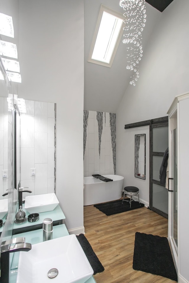 4512 General Forest Cir, Bon Aqua, TN 37025 - bathroom with a sink, vaulted ceiling with skylight, a freestanding tub, and wood finished floors