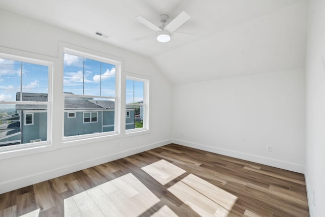 additional living space featuring wood finished floors, baseboards, a ceiling fan, and lofted ceiling