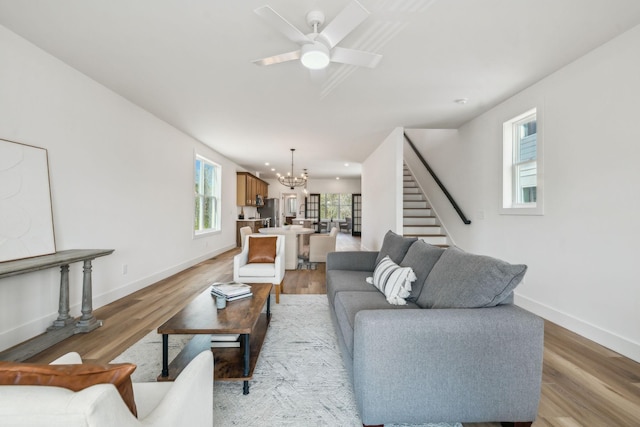 living room with stairway, baseboards, and light wood finished floors