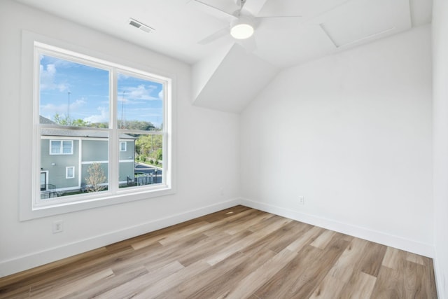 additional living space featuring ceiling fan, light wood-type flooring, visible vents, attic access, and baseboards