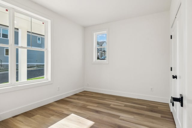 unfurnished room featuring baseboards and wood finished floors