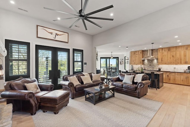 living area featuring recessed lighting, french doors, and light wood-type flooring