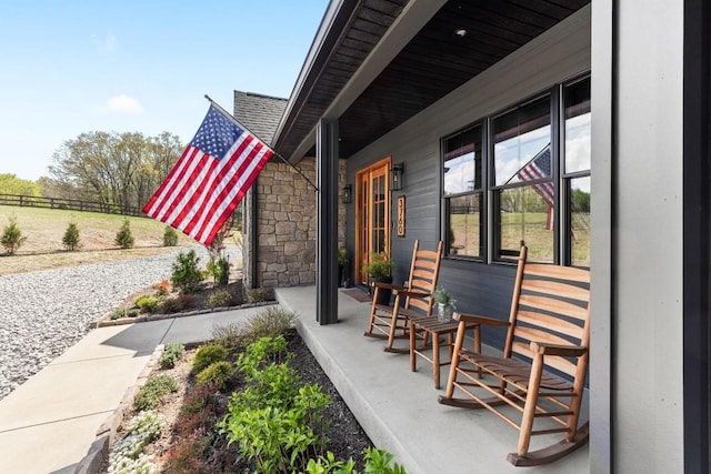 view of patio / terrace featuring a porch and fence