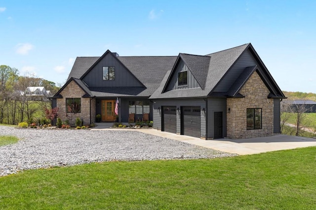 craftsman-style home featuring a garage, stone siding, and a front lawn