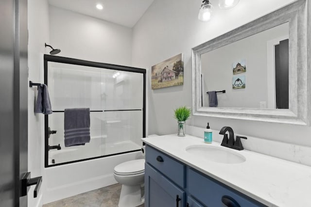 bathroom with bath / shower combo with glass door, vanity, and toilet