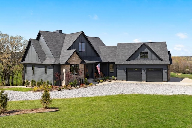 view of front of home featuring stone siding, a garage, board and batten siding, a front lawn, and driveway