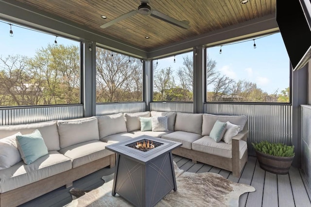 sunroom / solarium with a ceiling fan and an outdoor living space with a fire pit