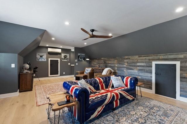 home theater featuring an accent wall, an AC wall unit, ceiling fan, wood finished floors, and lofted ceiling