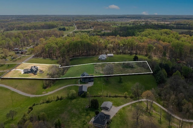 birds eye view of property featuring a forest view