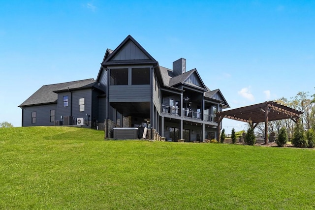 rear view of house with board and batten siding, a yard, a pergola, and central AC