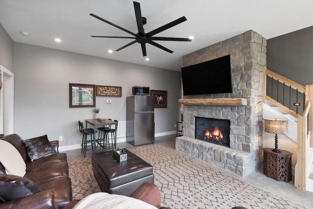 living area featuring baseboards, recessed lighting, a fireplace, stairs, and ceiling fan