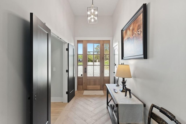 doorway to outside featuring an inviting chandelier, baseboards, and a water view