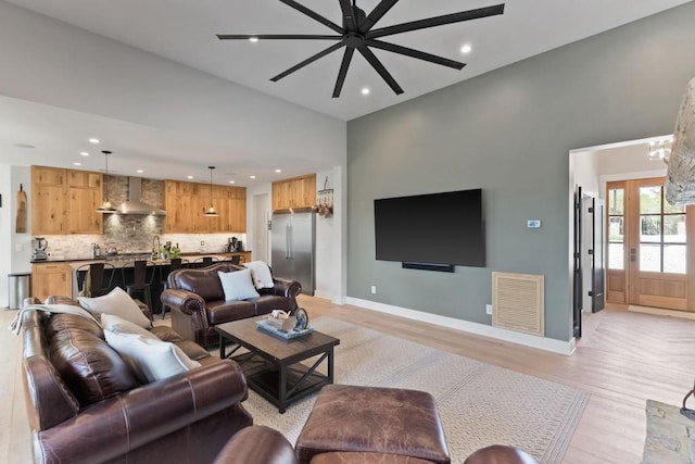 living area with recessed lighting, visible vents, and baseboards