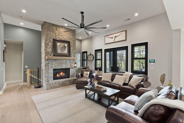 living room with visible vents, recessed lighting, a stone fireplace, and hardwood / wood-style flooring