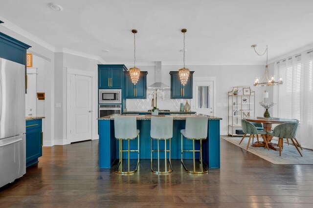 779 Newcomb St, Franklin, TN 37064 - kitchen featuring stainless steel appliances, blue cabinetry, wall chimney exhaust hood, a chandelier, and decorative backsplash