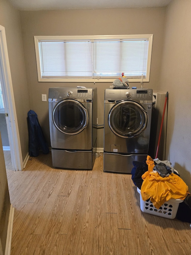 laundry room featuring plenty of natural light, wood finished floors, and separate washer and dryer