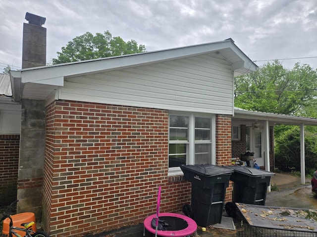 view of side of property with brick siding and a chimney