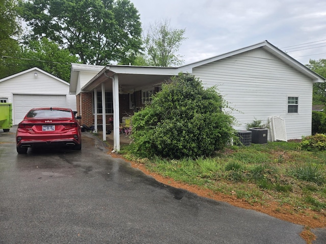 view of home's exterior featuring a garage, an outbuilding, and driveway