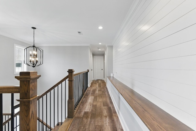 hallway with an upstairs landing, crown molding, a notable chandelier, and dark wood-style floors