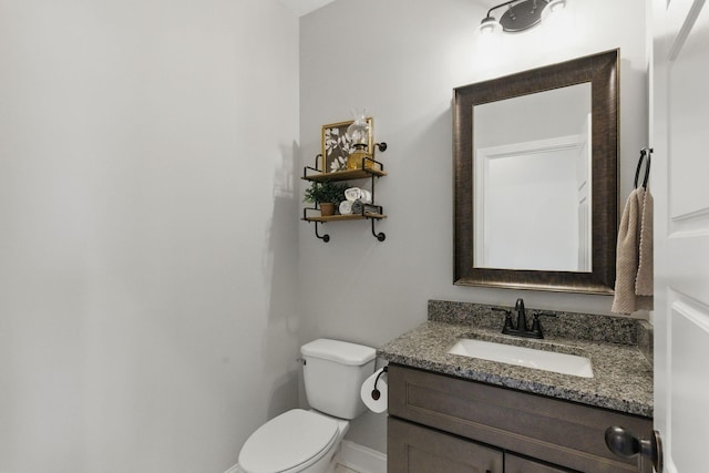 bathroom featuring vanity, toilet, and baseboards