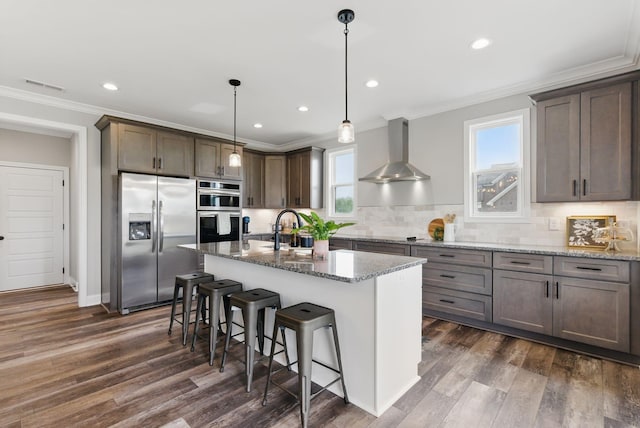 kitchen featuring stainless steel appliances, crown molding, visible vents, wall chimney range hood, and plenty of natural light
