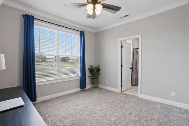 spare room with a healthy amount of sunlight, light carpet, baseboards, a ceiling fan, and crown molding
