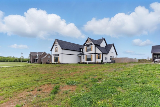 modern farmhouse style home featuring central AC, fence, a chimney, and a front lawn