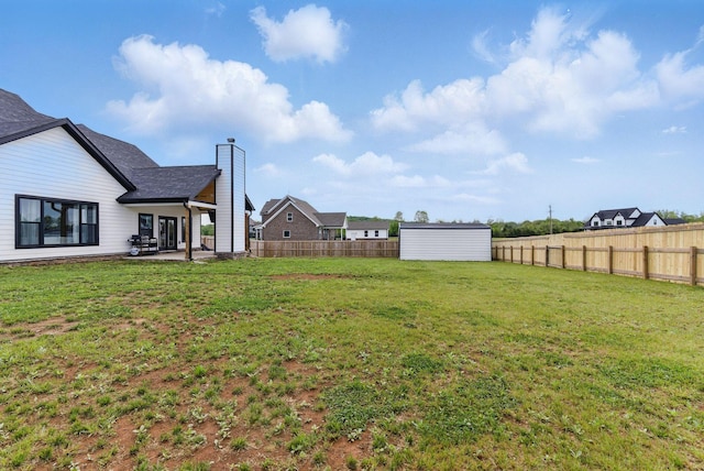 view of yard featuring an outdoor structure, a patio, a fenced backyard, and a storage shed