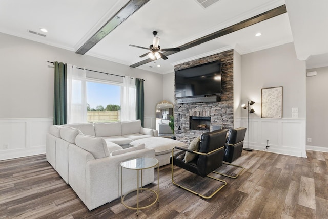 living area featuring wood finished floors, a fireplace, visible vents, a ceiling fan, and crown molding