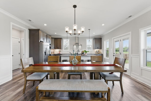 dining area featuring visible vents, a healthy amount of sunlight, dark wood-style flooring, and an inviting chandelier
