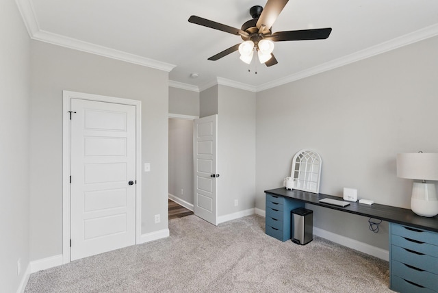 unfurnished office with crown molding, baseboards, a ceiling fan, and light carpet
