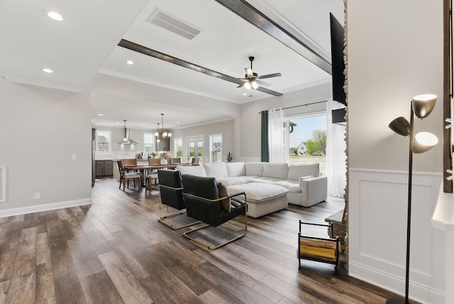 living room featuring visible vents, ornamental molding, ceiling fan, and dark wood-style flooring