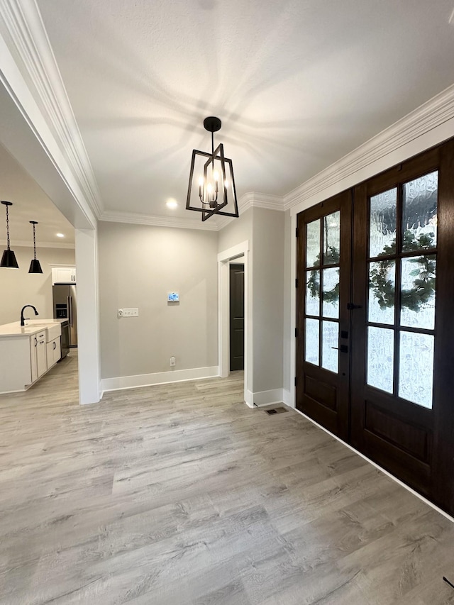1049 Veridian Dr Unit A, Clarksville, TN 37043 - foyer featuring french doors, a chandelier, baseboards, ornamental molding, and light wood-style floors