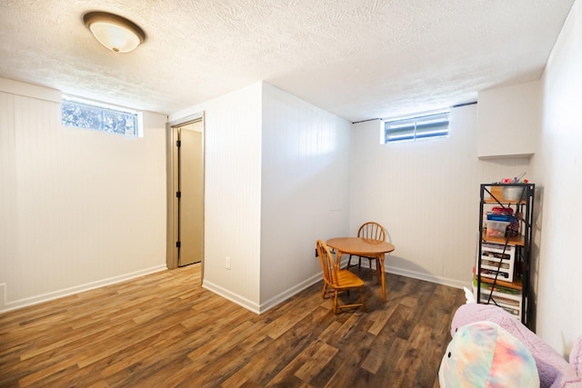 game room with a textured ceiling, wood finished floors, and baseboards