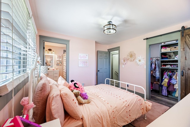 bedroom with ensuite bath, a closet, and a barn door
