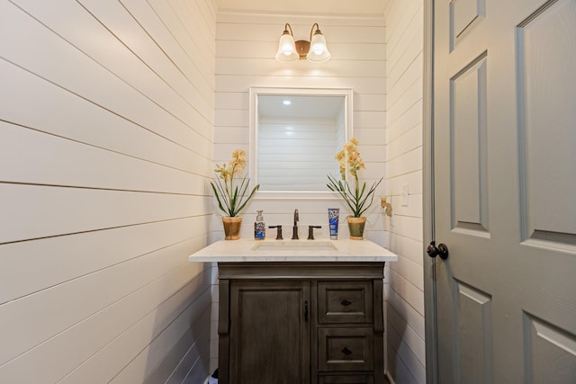 bathroom with vanity and wooden walls