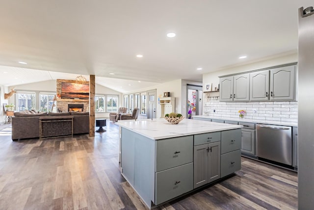 kitchen featuring vaulted ceiling, a center island, gray cabinetry, dark wood finished floors, and dishwasher